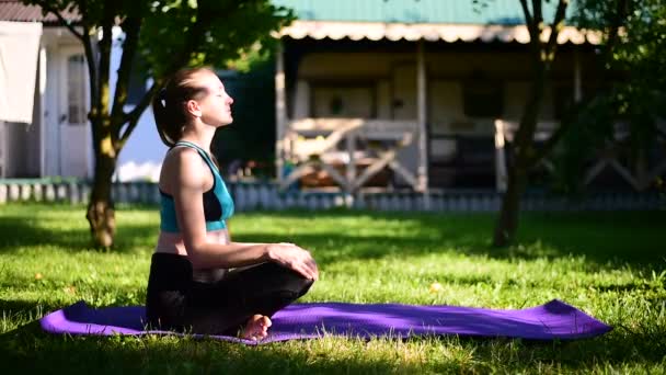 Zwangere vrouw in de tuin beoefent yoga. Zomer ochtend. — Stockvideo