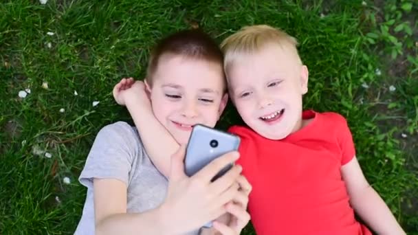 Blonda Och Mörkhåriga Pojkar Låg Gräs Skojade Och Tog Selfies — Stockvideo
