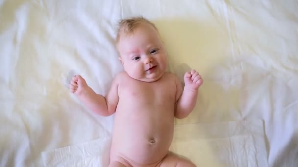 Cute Baby Lying White Bed Smiles Funny Moves Hands Feet — Stock Video