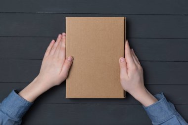 Siyah arka planda çocukların elinde karton kutu. Üst Manzara. Boşluğu kopyala.