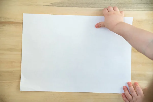 Barnens Hand Håller Blankt Vitt Papper Ark Trä Bakgrund Uppfattat — Stockfoto