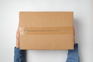 Eller büyük karton kutu tutuyor. Ev konseptine paket teslimatı. Üst görünüm