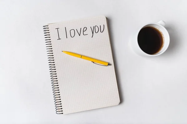 I love you, written on notebook. Morning coffee and message for loved. White background.