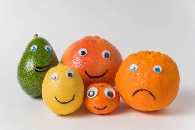 Avokado limonlu portakallı mandalina ve komik yüzlü greyfurt ve şaşı gözler. Büyük aile kavramı.
