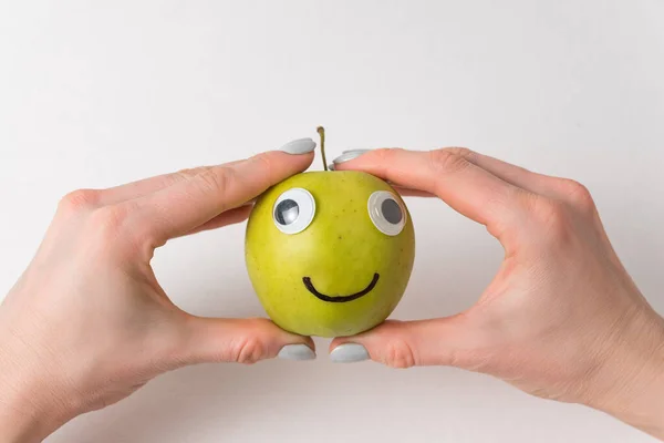 Ręce Trzymając Słodkie Jabłko Google Oczy Narysowany Uśmiech Haracter Apple — Zdjęcie stockowe