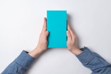 Çocuğun beyaz arka planda dikdörtgen mavi bir kulübesi var. Üst Manzara. Çocuk için hediye.