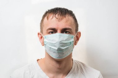 Koruma maskeli adam. Beyaz arka planda cerrahi maske takan bir doktor. Mikroplardan korunma.