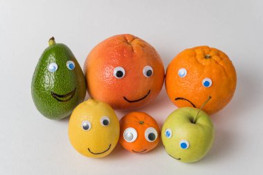 Avokado, limon, Mandarin, Apple, greyfurt ve şaşı gözlü turuncu karakterler. Çok uluslu aile kavramı.