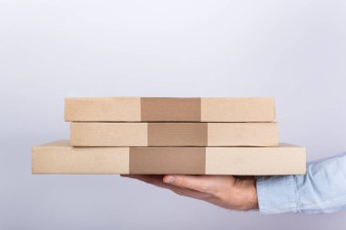 Beyaz arka planda pizza kutularıyla el ele tutuşmak. Yan Görünüm. Kurye teslimatı.