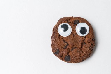 Beyaz arka planda şaşı gözlü çikolatalı kurabiyeler. Komik suratlı kurabiyeler..