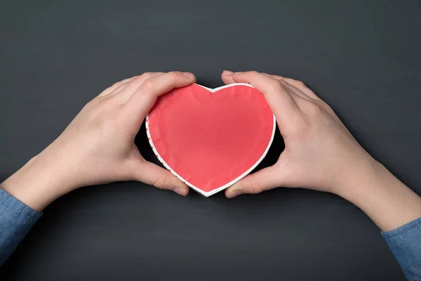 Çocukların Elleri Siyah Arka Planda Kırmızı Kalp Şeklinde Bir Kutu — Stok fotoğraf