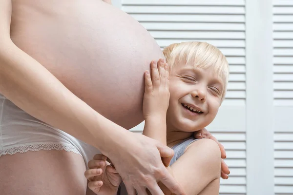 Chlapec Opřel Uchem Břicho Těhotné Matky Usmál Mladá Těhotná Žena — Stock fotografie