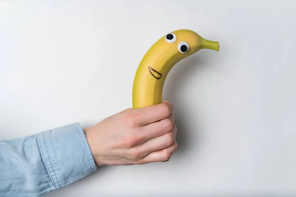 Mano Sosteniendo Plátano Con Cara Divertida Concepto Snack Rápido Vegano — Foto de Stock