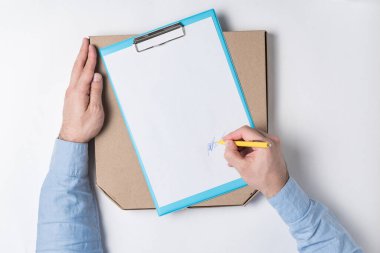 Pizza kutusu ve erkek eli belgeye imza atıyor. Ev konseptine yiyecek teslimatı.