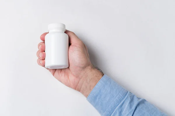手拿着一罐白色药丸 在白色背景下模拟的药物容器 — 图库照片