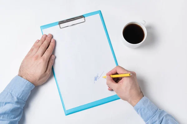 Top view of man hands, papers and Cup of coffee. Man signs paper. copy space backdrop pattern.