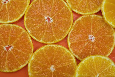 Turuncu zemin üzerinde taze dilimlenmiş portakal suyu seti - arka plan kullanımı için tropikal portakal meyve dokusu