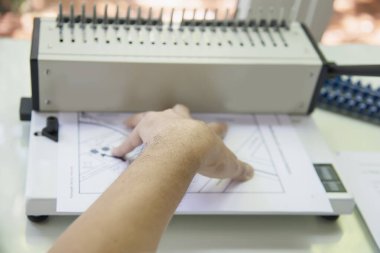 Tarak bağlayıcı makine kullanarak rapor hazırlayan adam - sabit araçlar konseptiyle çalışan insanlar