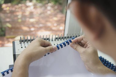 Tarak bağlayıcı makine kullanarak rapor hazırlayan adam - sabit araçlar konseptiyle çalışan insanlar