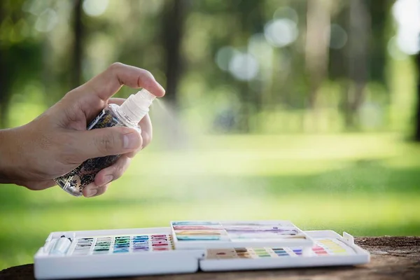 Relax woman painting water colour art work in green garden forest nature - people with creative art in nature stress reduction and meditation concept