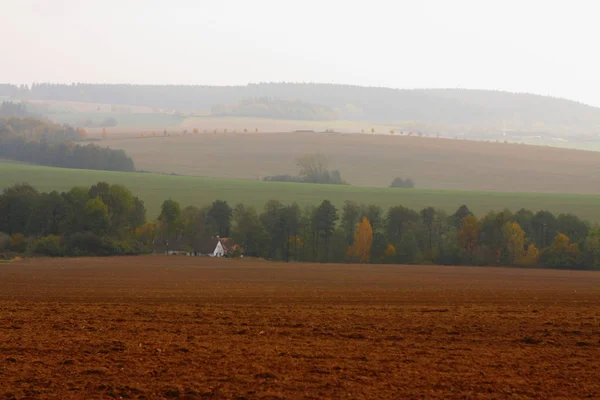 Podzimní pole s farmou uprostřed kopců — Stock fotografie