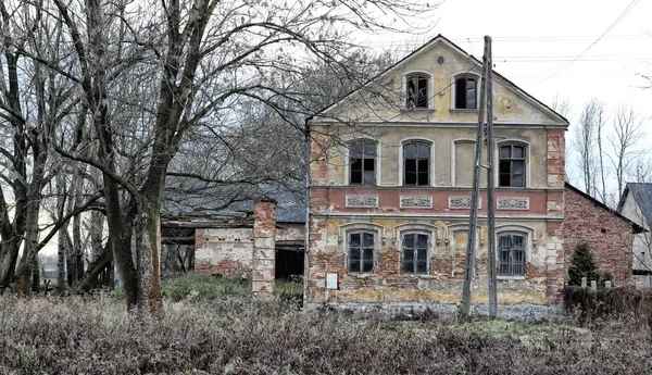 Старый заброшенный дом с разбитыми окнами — стоковое фото