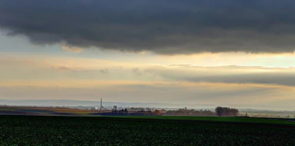 Pole před bouří s vzdálené město — Stock fotografie