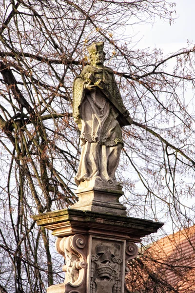 Estátua velha do santo com a cruz — Fotografia de Stock