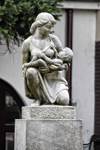 Stone symbol of maternity with mother and child