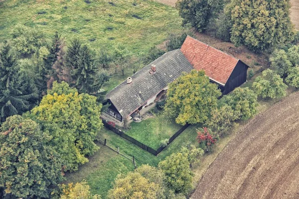 Oud huis met de schuur door het veld — Stockfoto
