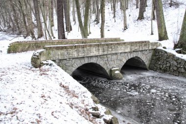 Buzlu nehir üzerinde eski taşlı köprü