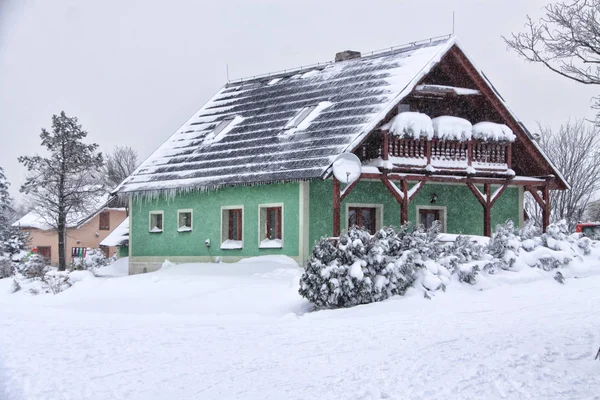 Zielony dom w śniegu z drewnianym balkonem — Zdjęcie stockowe