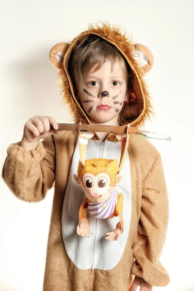 Хлопчик одягнений для лева з паперовою мавпою в руках — стокове фото
