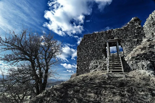 Rovina del vecchio castello con scale di legno sotto il cielo blu intenso — Foto Stock