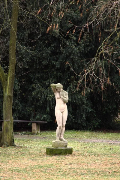 Estátua da menina nua em pé junto à árvore no parque — Fotografia de Stock
