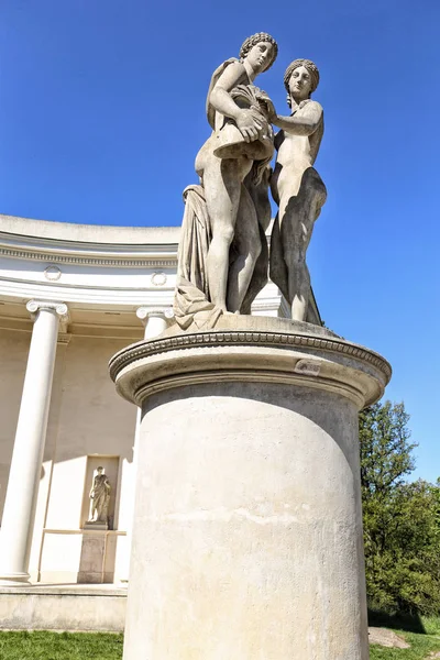 Statue de jeunes femmes debout sur un haut piédestal — Photo