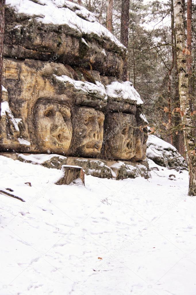 Snow covered rock with engraved faces