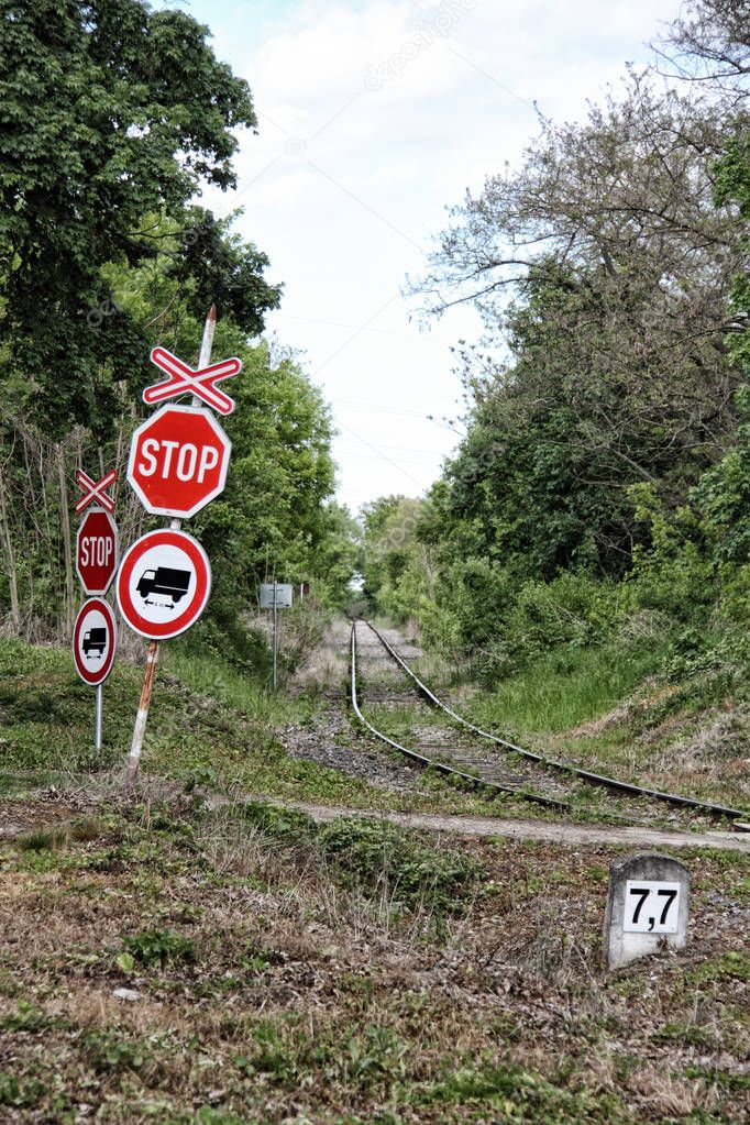 Stop signs with cross by straight railway