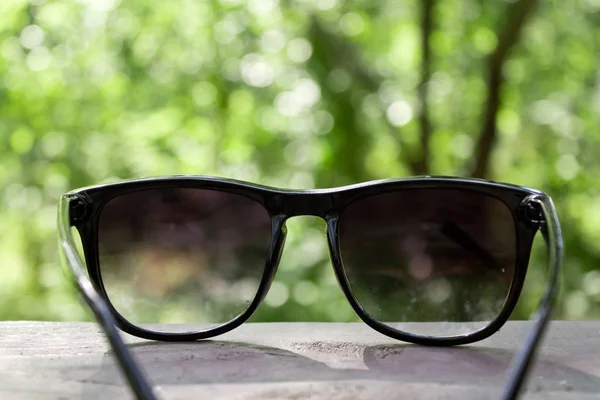 Glasses on a wooden table in a forest — Stock Photo, Image