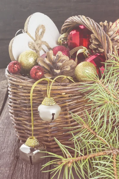 Christmas jewelry in a basket on a wooden background. Toning