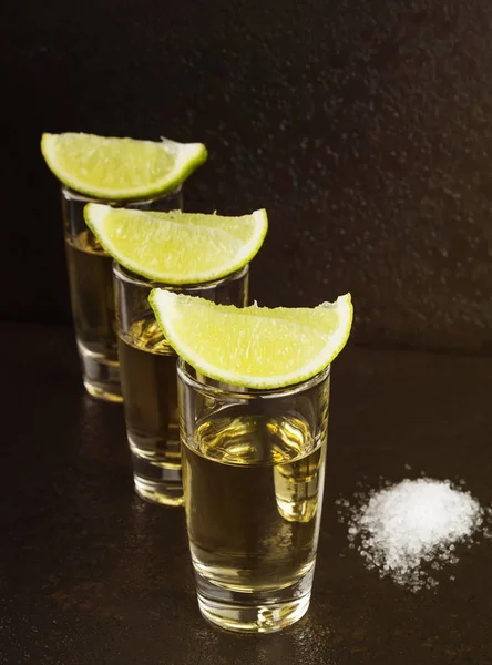 Tequila mit Salz und Limette auf dunklem Hintergrund — Stockfoto