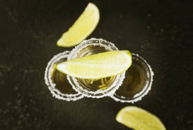 Tuz ve limon karanlık bir arka plan üzerinde tekila. Tonlama