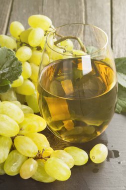 Beyaz şarap ve üzüm karanlık bir arka plan üzerinde. Tonlama