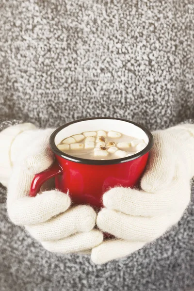 Mädchen hält einen Becher heißen Kakao mit Marshmallows in Fäustlingen. Straffung. — Stockfoto