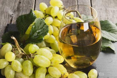 Beyaz şarap ve üzüm karanlık bir arka plan üzerinde