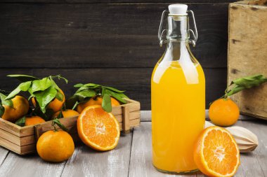 Şişe mandalina suyu ve ahşap bir zemin üzerine taze meyve