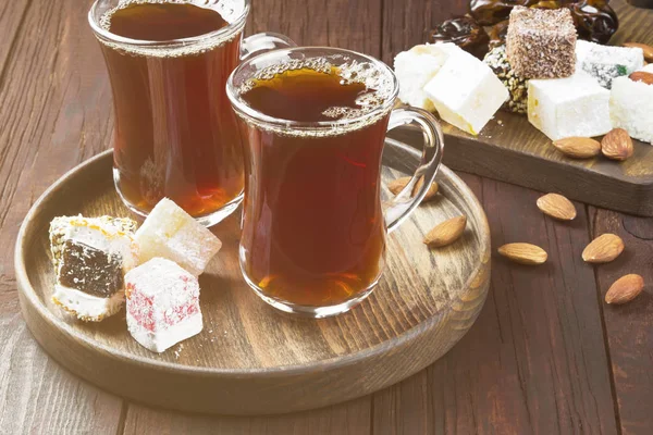 Černý čaj, orientální cukrovinky, data a ořechy — Stock fotografie