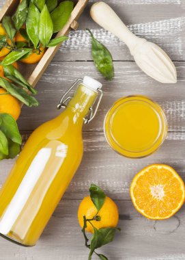 Şişe mandalina suyu ve ahşap bir zemin üzerine taze meyve