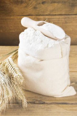 Çanta ve buğday ahşap arka plan kulaklara un. Tonlama.