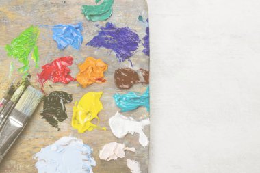 Çeşitli sanat yağlı boya bir ahşap palet ve bir fırça. Üstten Görünüm
